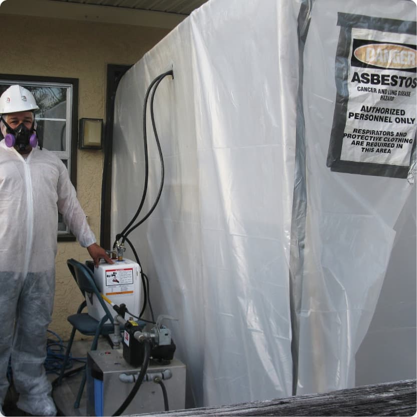 Asbestos contractor standing next to asbestos decontamination entrance