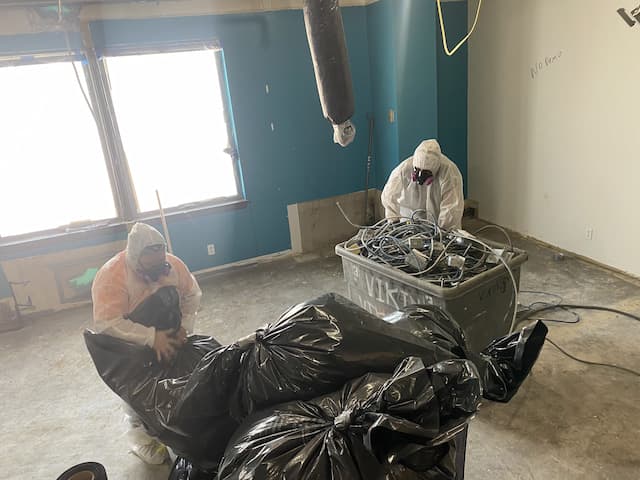 Asbestos contractors cleaning up after abatement